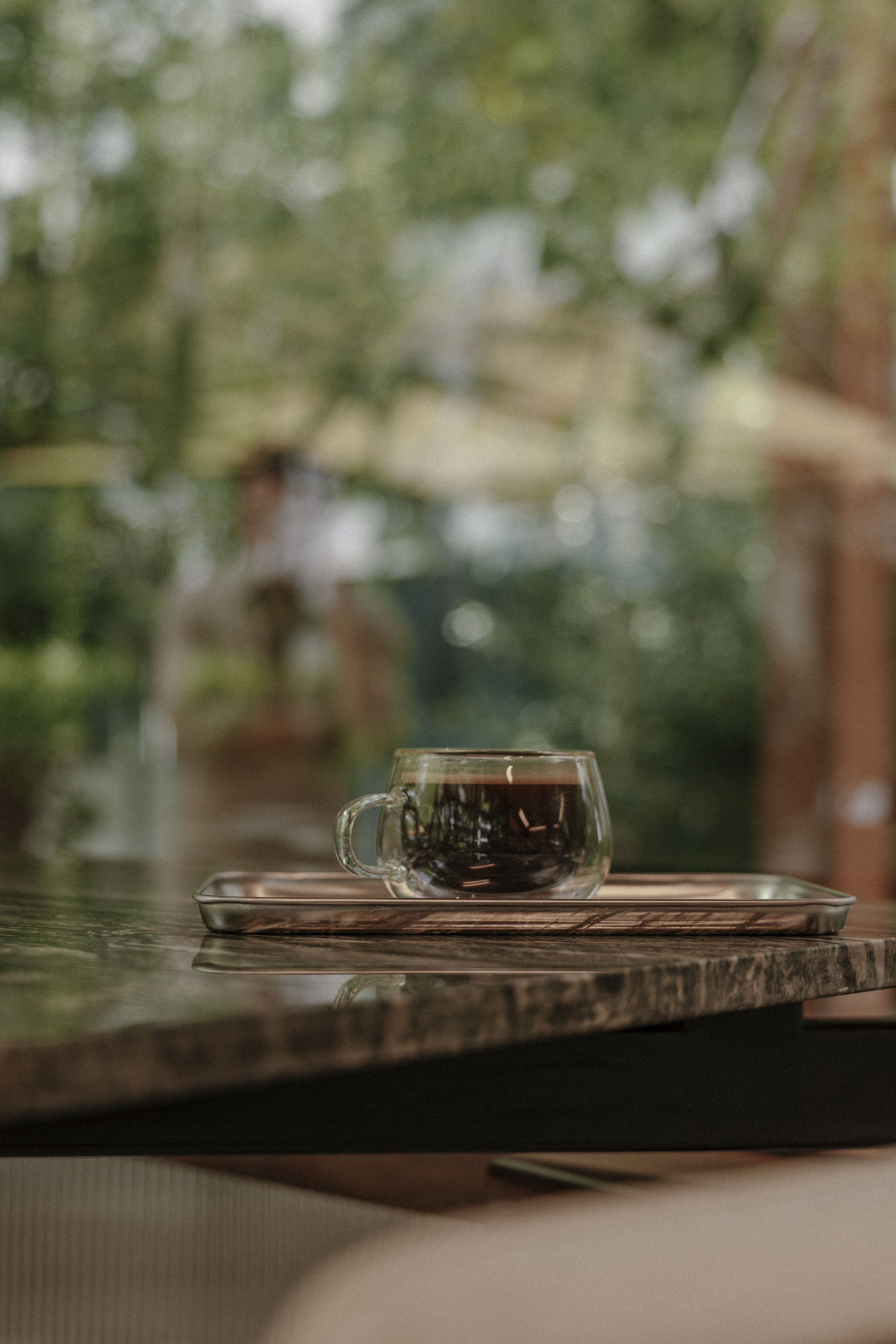 Specialty coffee on green marble at Café LOM — garden in the background
